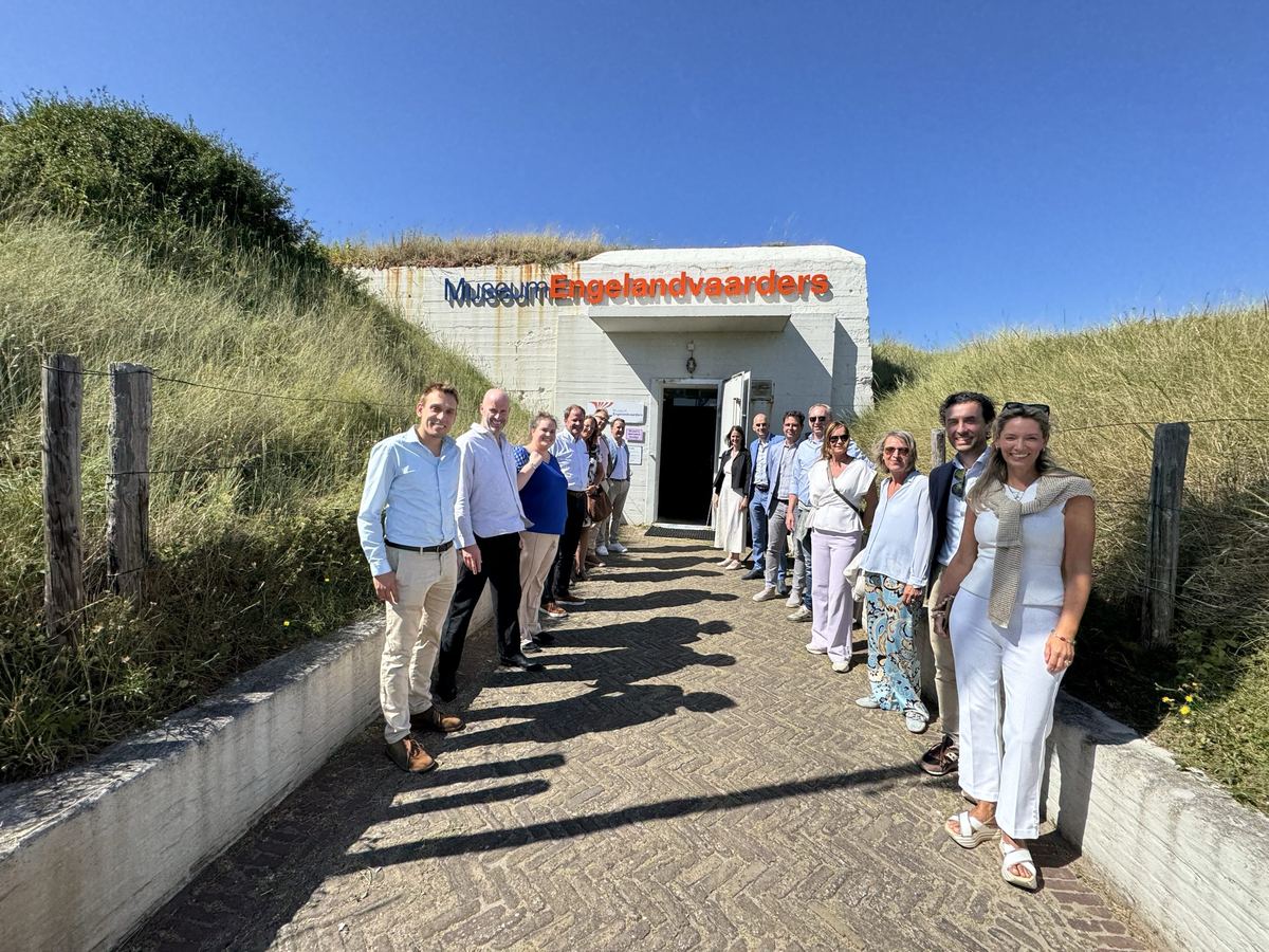 Lange rij bezoekers in lichte kleding op het pad naar de ingang van het museum