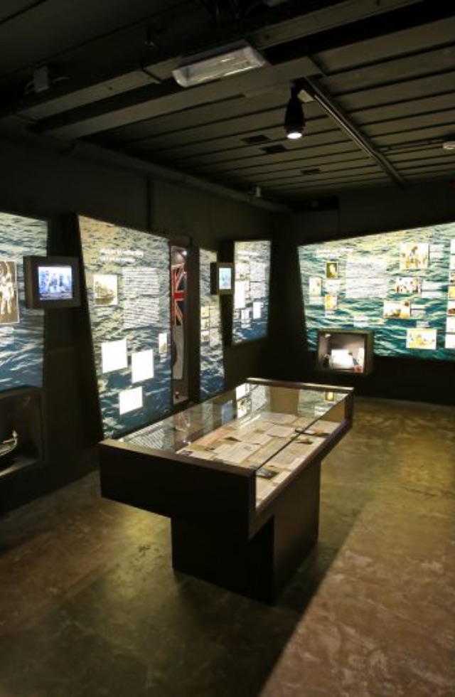 Het interieur van het museum in de bunker, met vitrines en projecties van de zee