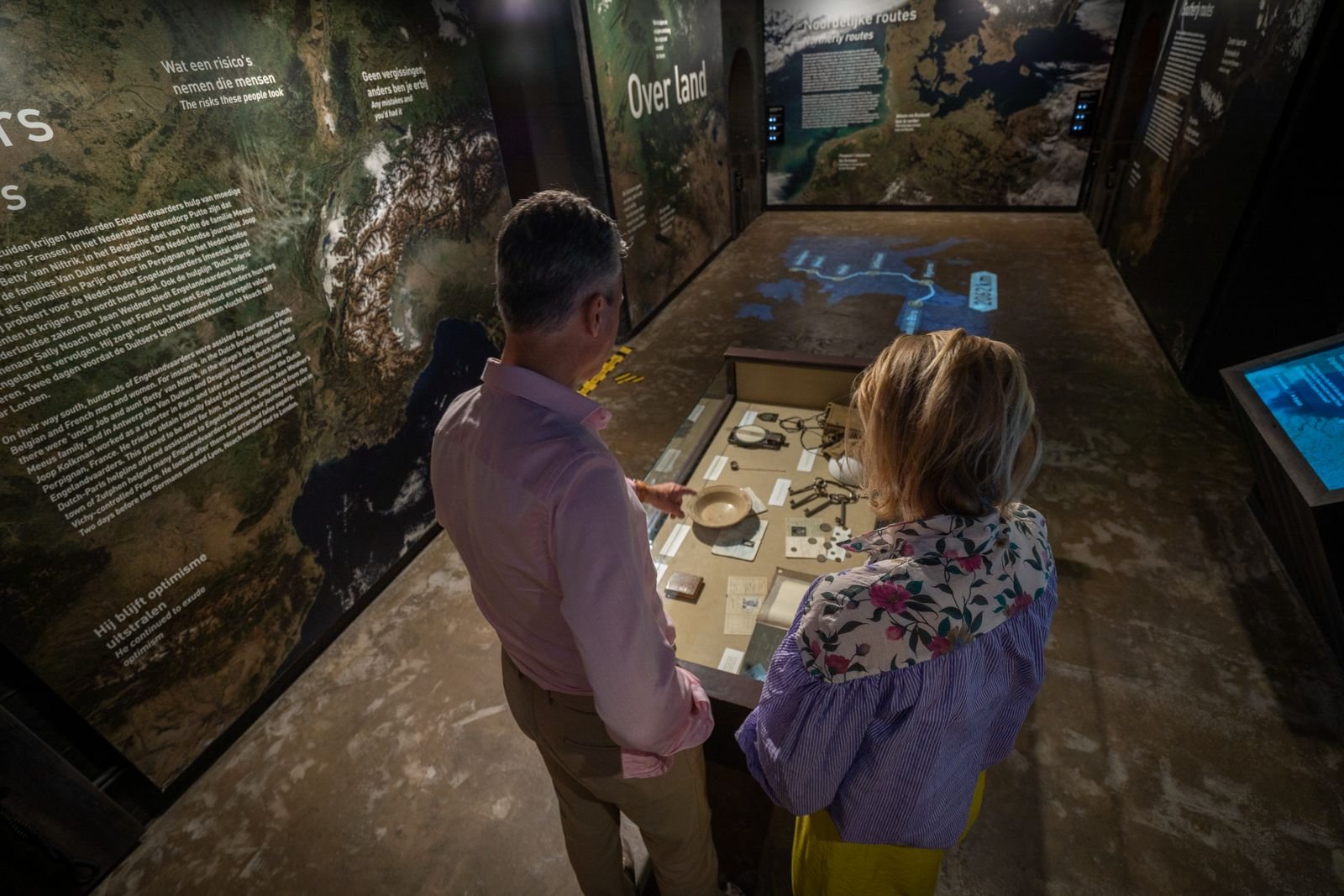 Vitrine en kaartwand in het museum, met de vluchtroutes naar Engeland